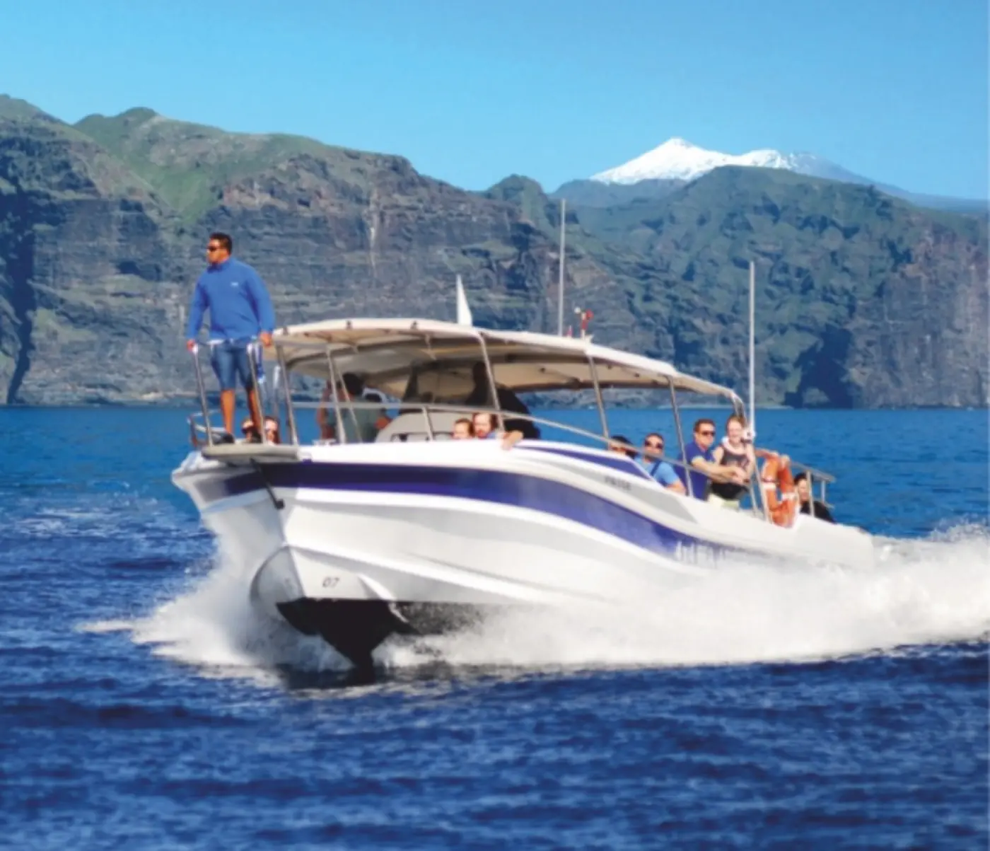 Bateau d'observation naviguant devant les falaises de Los Gigantes, le Teide au fond