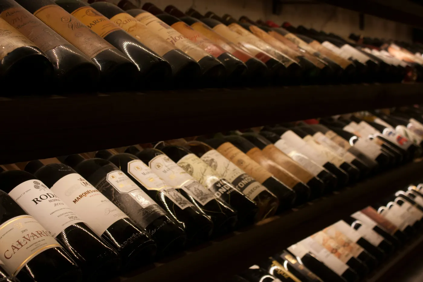 Botellas de vino en reposo sobre los estantes de madera de una bodega
