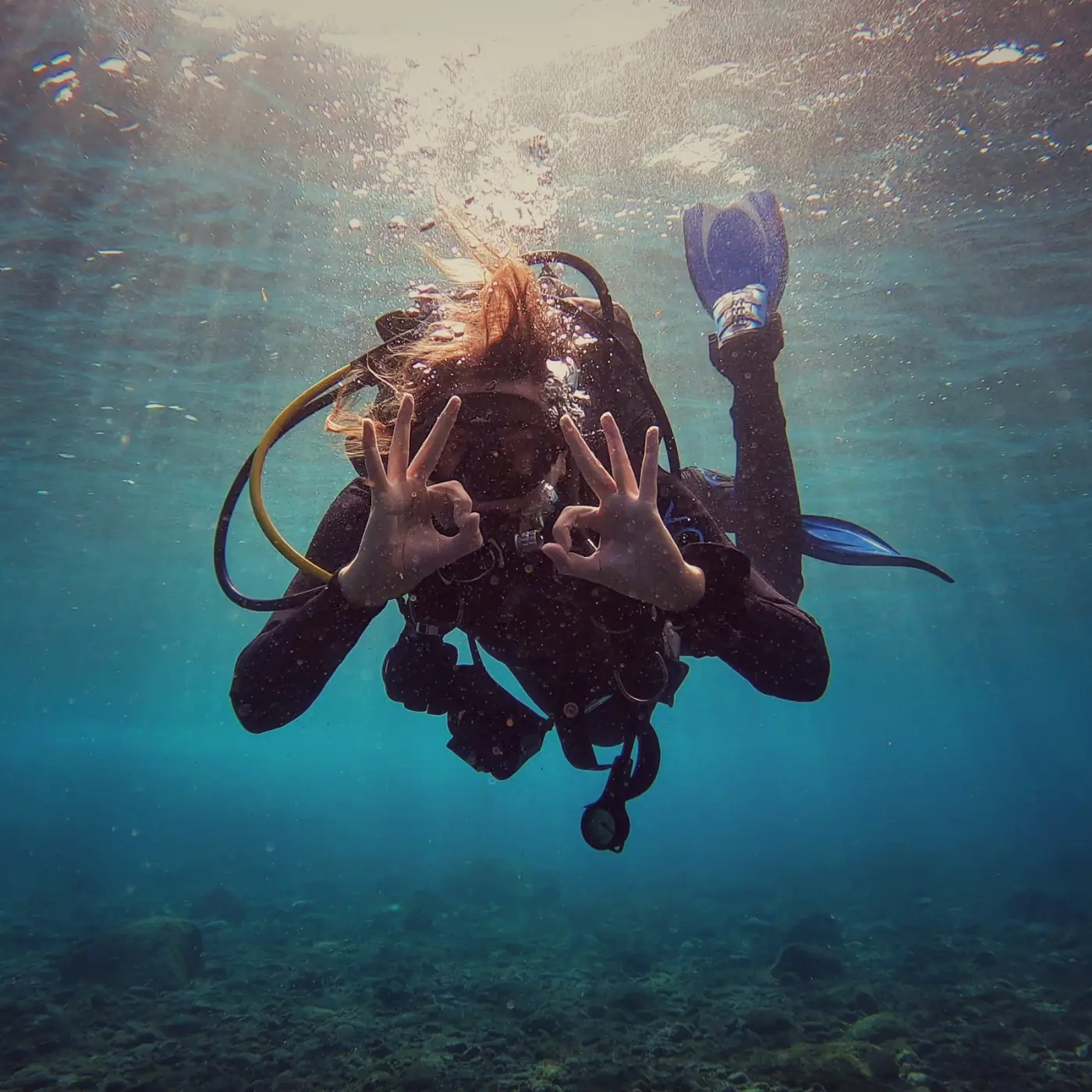 A diver underwater giving the OK signal