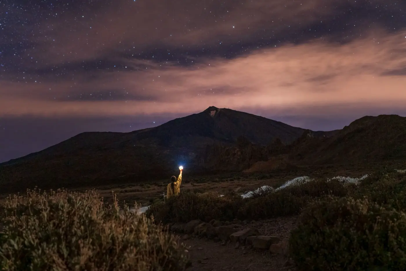 Eine Person beobachtet nachts den Sternenhimmel am Teide