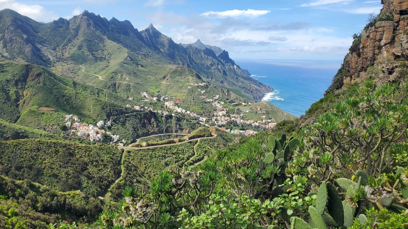 A hamlet among green mountains with the sea beyond, in northern Tenerife