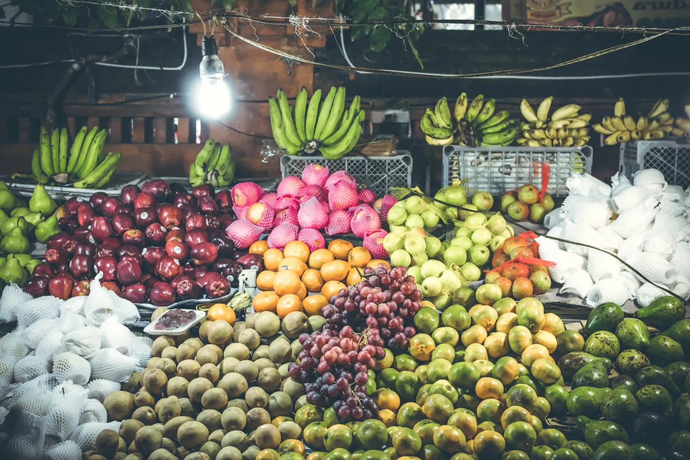 Obststand mit Bananen, Trauben und Saisonobst