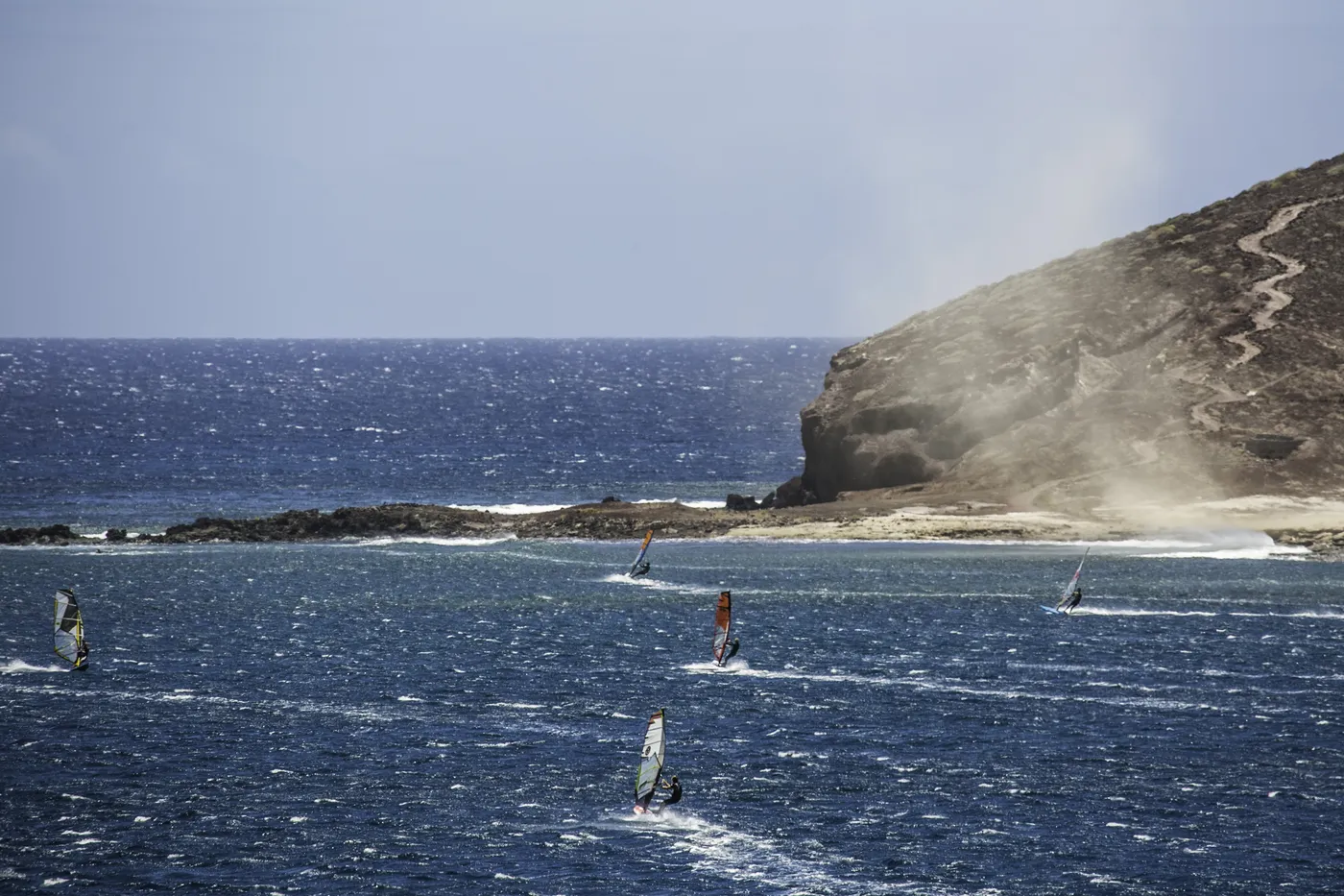Windsurfeurs naviguant dans la baie d'El Médano avec la Montaña Roja