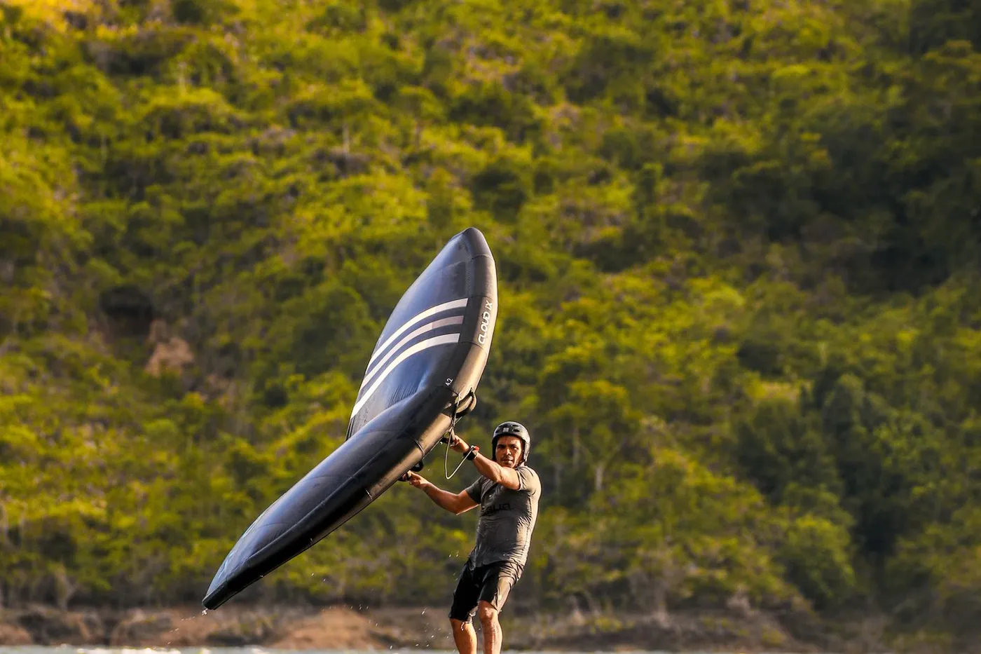 Persona sujetando el wing sobre la tabla de foil antes de despegar